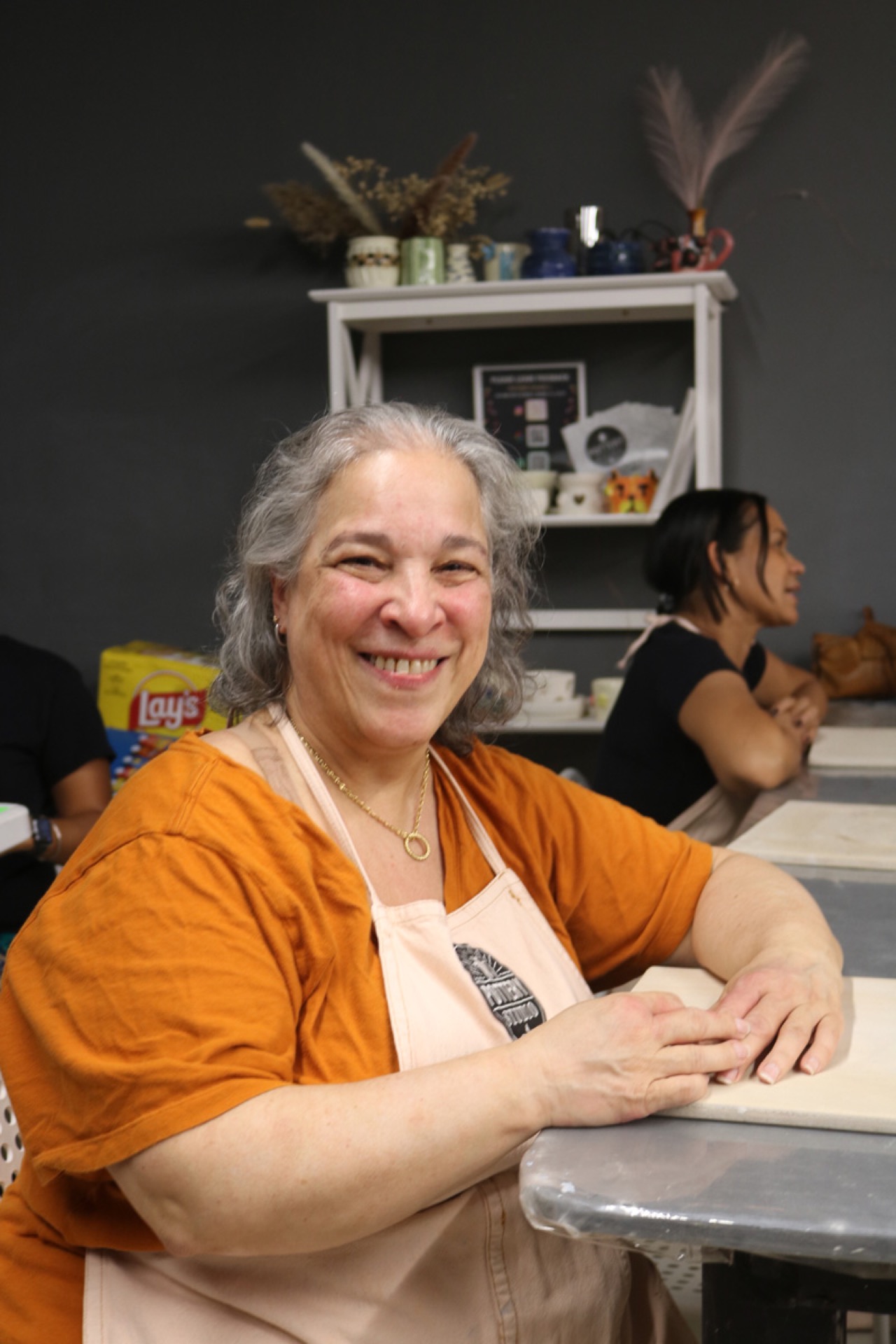 A participant smiling at the pottery workshop