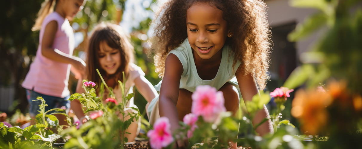 Children planting flowers together in a community garden